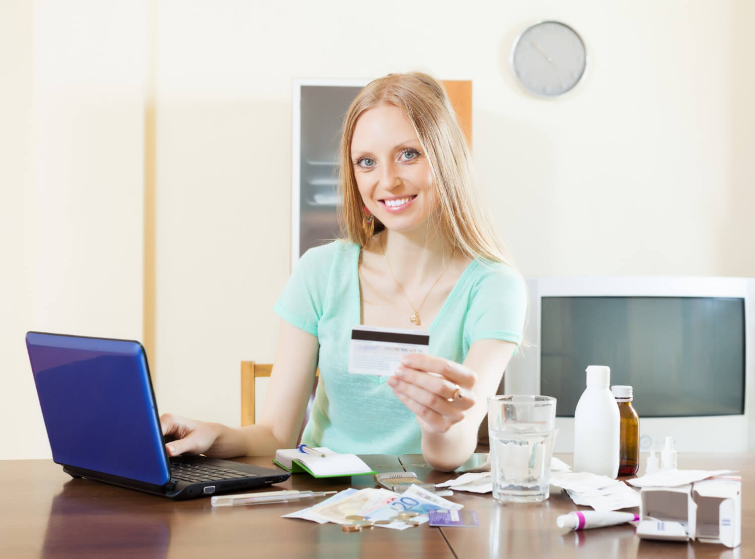 Woman purchasing medication online using her credit card on a secure pharmacy website.