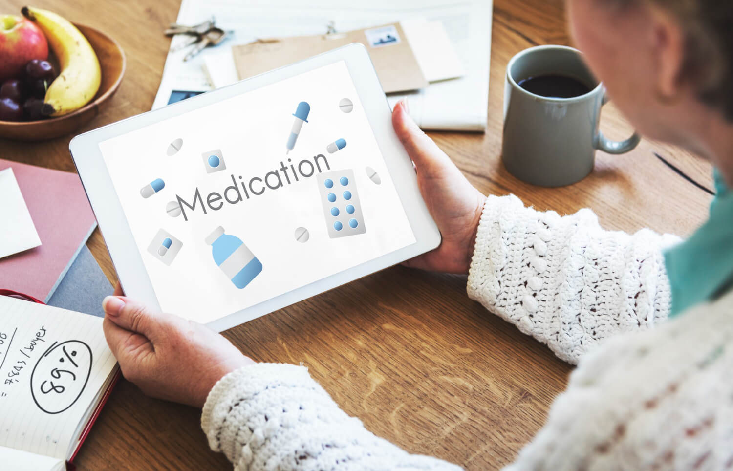 Woman using a tablet displaying medication information for an online medication refill.