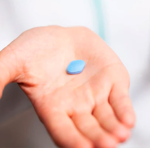 Blue tablet medicine in a person’s palm for medical treatments.